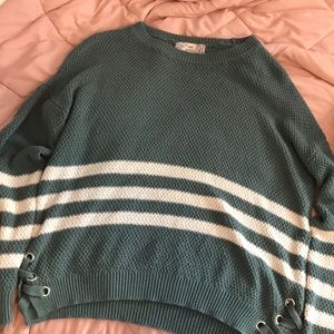 A green knitted sweater with whit strips